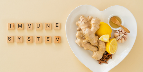 Ginger, lemon, garlic, and honey on a heart-shaped plate next to immune system letter tiles.