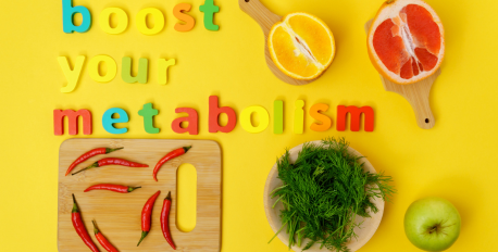 Fresh citrus, chili peppers, and greens on a yellow background with the text boost your metabolism