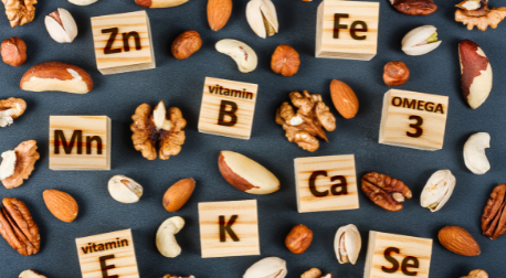 Wooden blocks with mineral symbols like Zn and Ca scattered among healthy nuts.