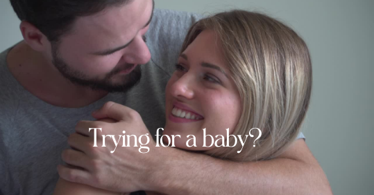 Happy young couple embracing and smiling with text overlay "Trying for a baby?
