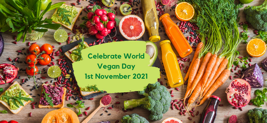 Flat lay of fresh vegetables, fruits, and juices surrounding a World Vegan Day sign.