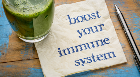 A green smoothie next to a napkin with "boost your immune system" written on it.