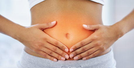 Woman holding her stomach with a glowing orange light highlighting her gut area