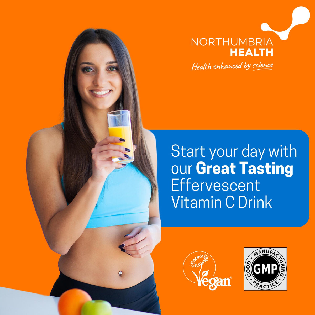 Smiling woman holding a glass of orange effervescent Vitamin C drink on an orange background.