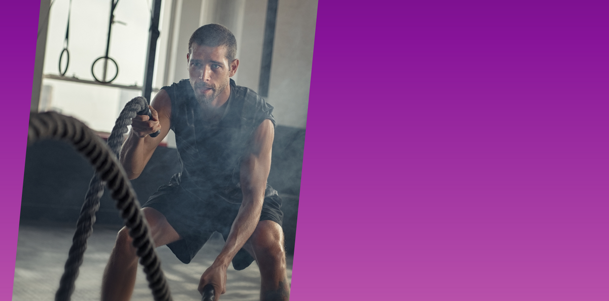 Man exercising with ropes in a gym setting