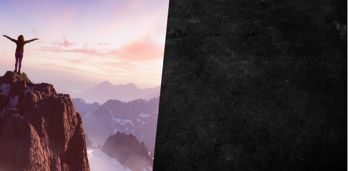 Person standing on a mountain peak with a scenic view of mountains and sky.