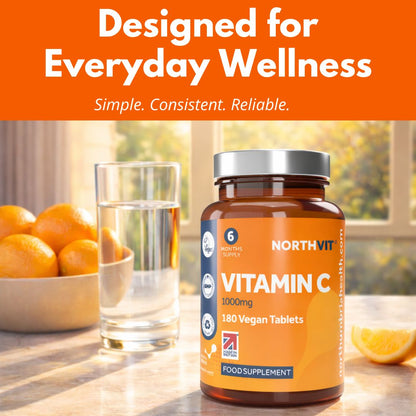 NorthVit Vitamin C 1000mg bottle next to a glass of water and fresh oranges.